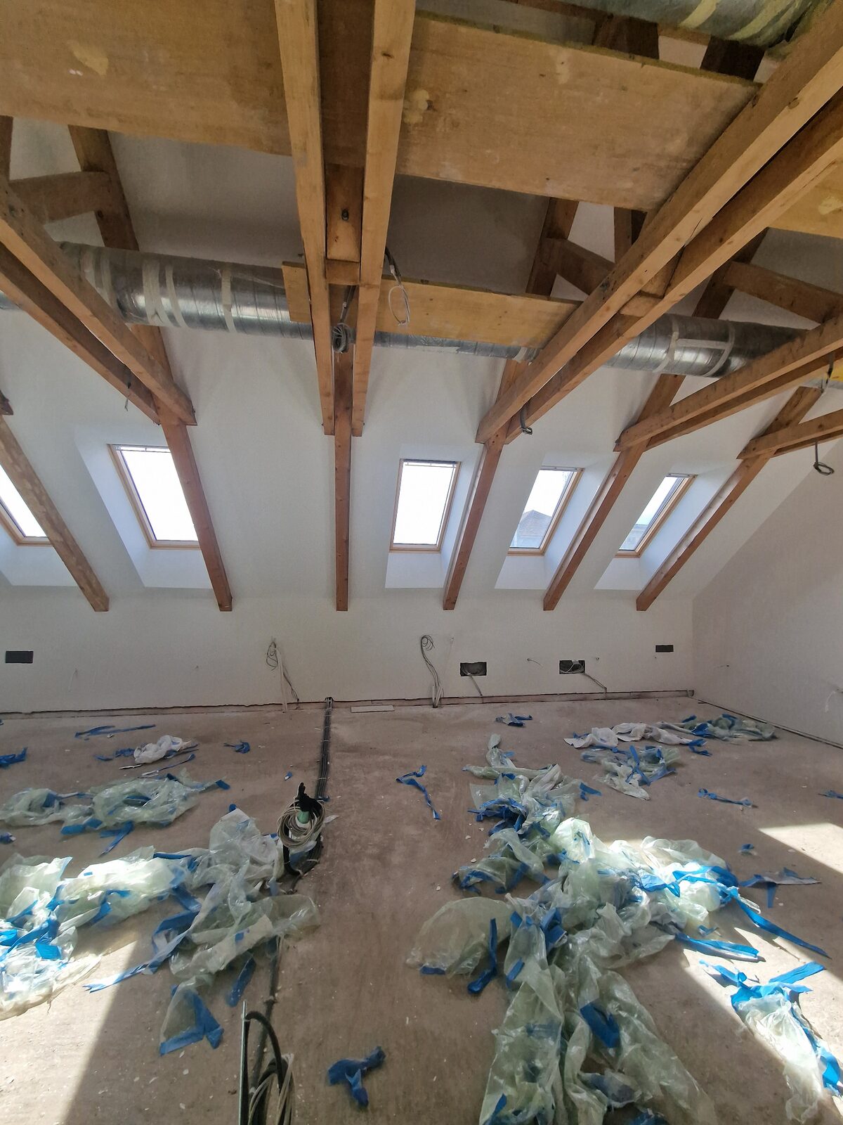Mansardă de apartament cu grinzi aparente, pereți zugrăviți alb — Cluj